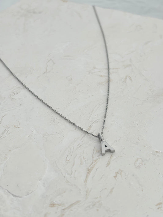A silver chain necklace with a small letter pendants, that can be personalise. A to Z letters gold and silver
