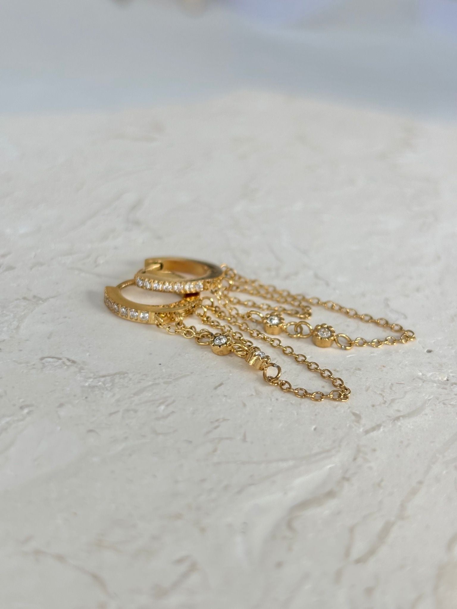 Gold earrings with elegant chain attached 