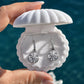 Sparkle Star Earrings in silver displayed in a white shell jewellery box against an ocean backdrop. Waterproof celestial huggie earrings with sparkling zircon star charms by Ocean The Label.